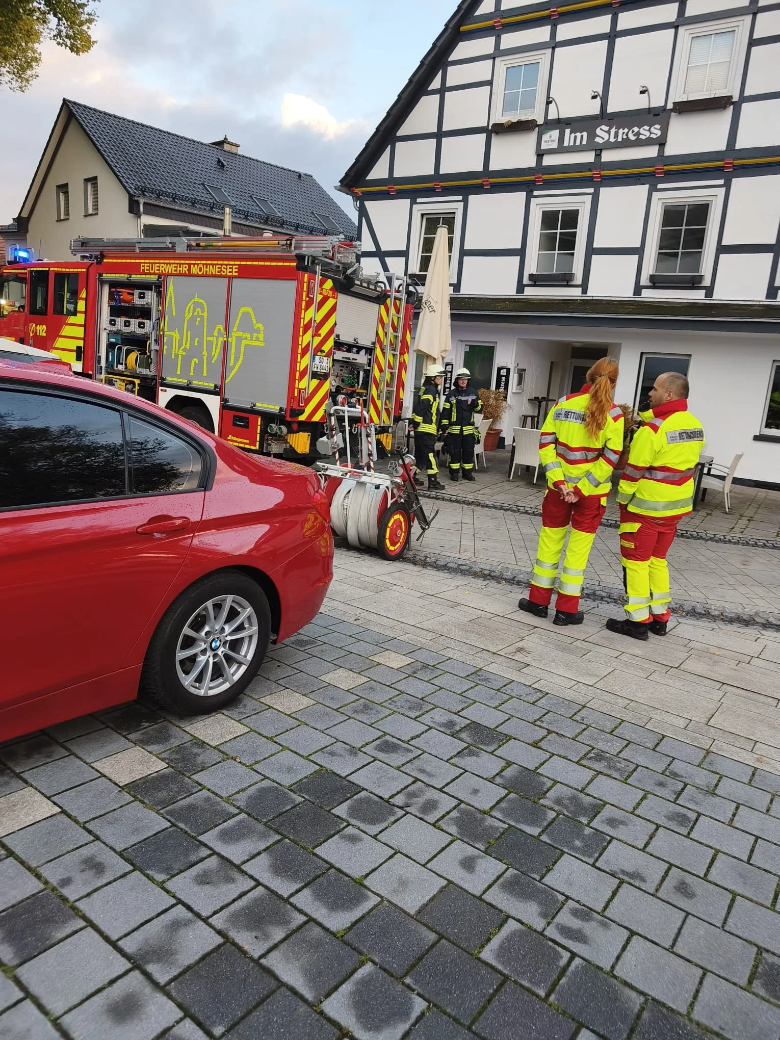 Feuerwehr- und Rettungsdienstkräfte vor der Gaststätte Im Stress.