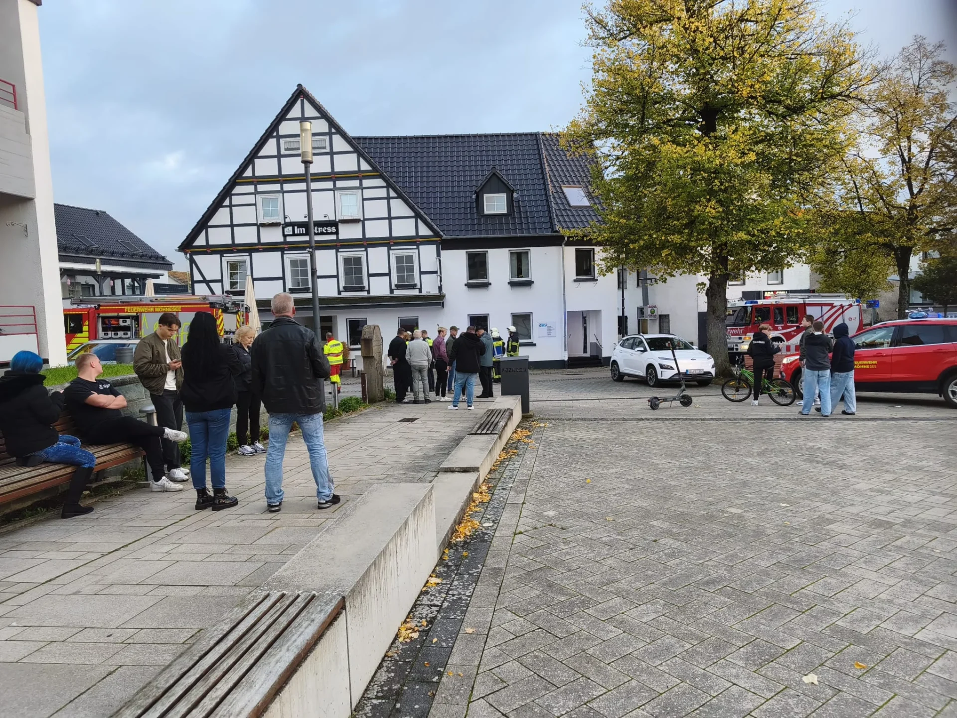 Gäste und Feuerwehr vor der Gaststätte Im Stress am Pankratiusplatz in Körbecke.