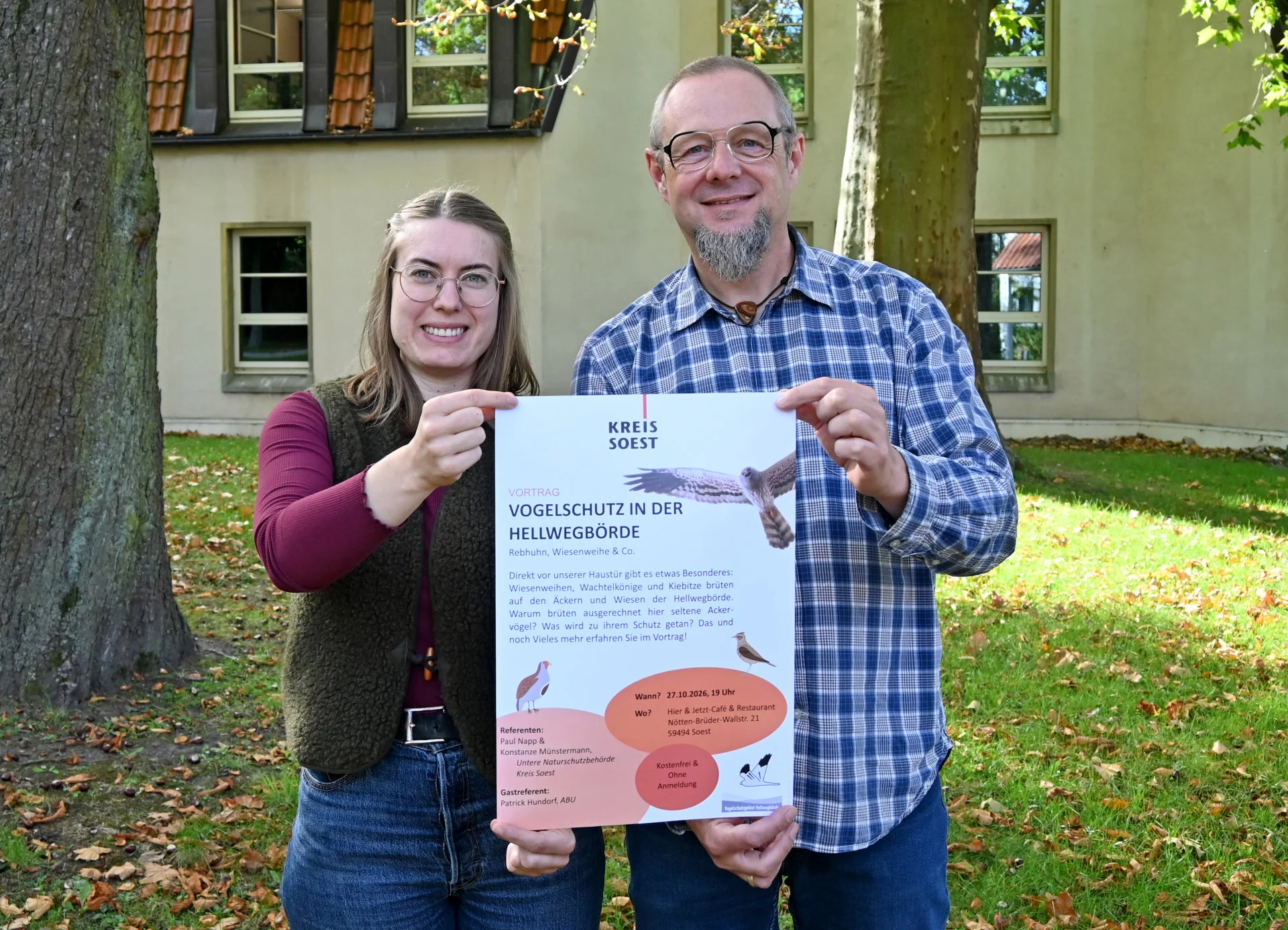 Konstanze Münstermann und Paul Napp halten das Plakat zum Vogelschutzabend.